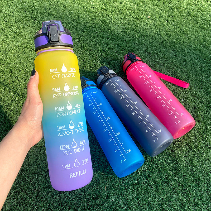 Four colorful water bottles with time markers on a grass background